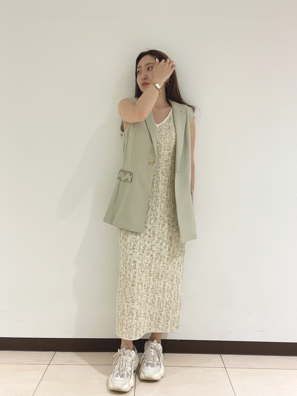 ホワイト系のワンピース、ベージュ系のベストを着用したレディースの春コーディネートの6枚目の写真