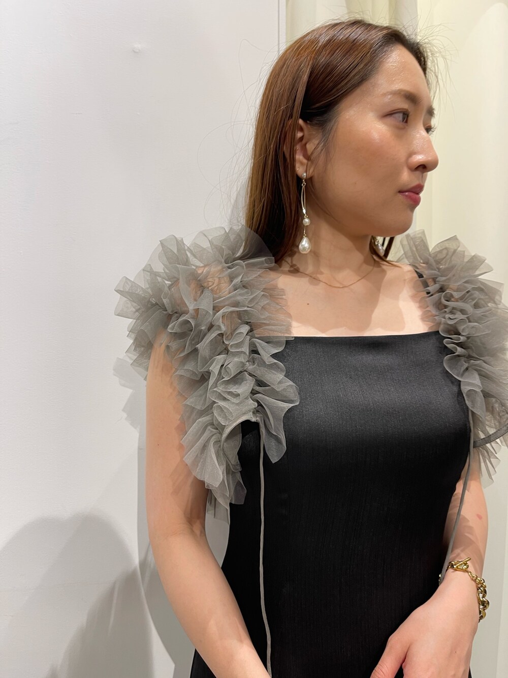 ブラック系のドレス、ゴールド系のピアス(両耳用)を着用したレディースの夏コーディネートの7枚目の写真