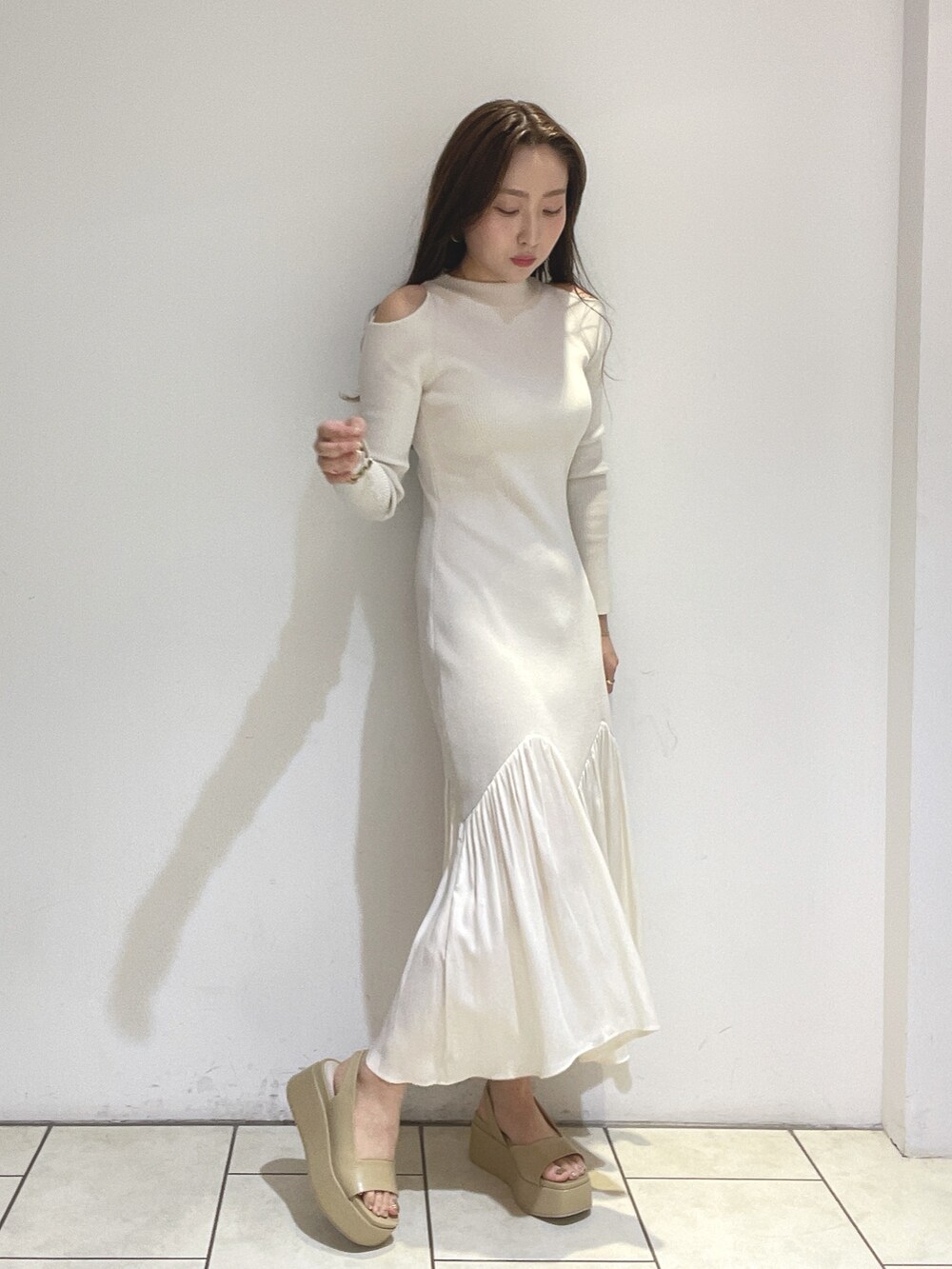 ホワイト系のワンピース、ベージュ系のサンダルを着用したレディースの冬コーディネートの6枚目の写真