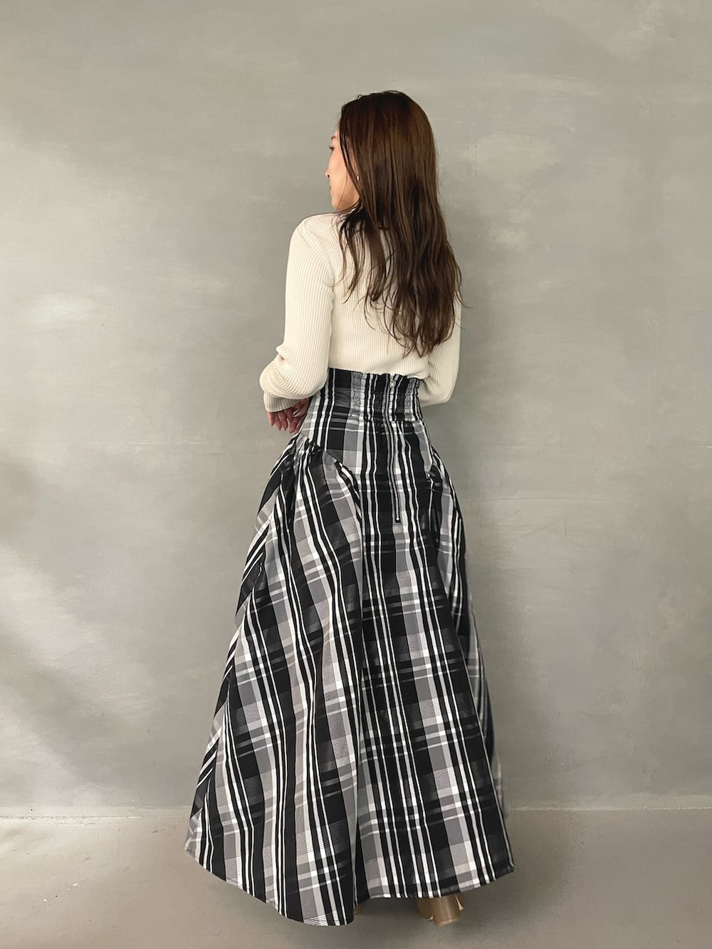 ベージュ系のブーツ、ホワイト系のニット/セーター、ホワイト系のスカートを着用したレディースの秋コーディネートの5枚目の写真