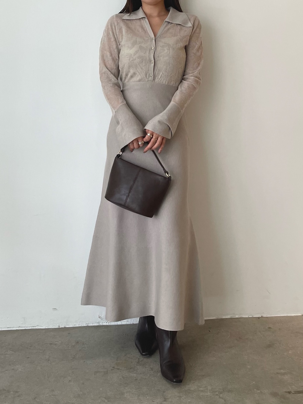 ブラウン系のハンドバッグ、ベージュ系のワンピース、ブラウン系のブーツを着用したレディースの秋コーディネートの3枚目の写真