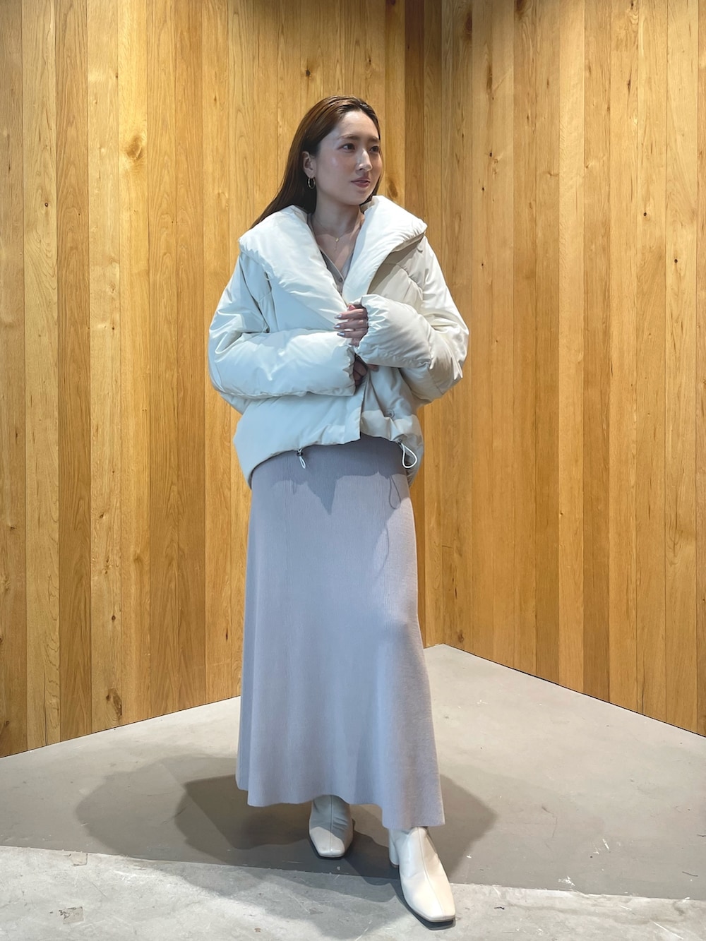 ホワイト系のブーツ、グレー系のワンピース、ホワイト系のダウンジャケット/コートを着用したレディースの秋コーディネートの3枚目の写真