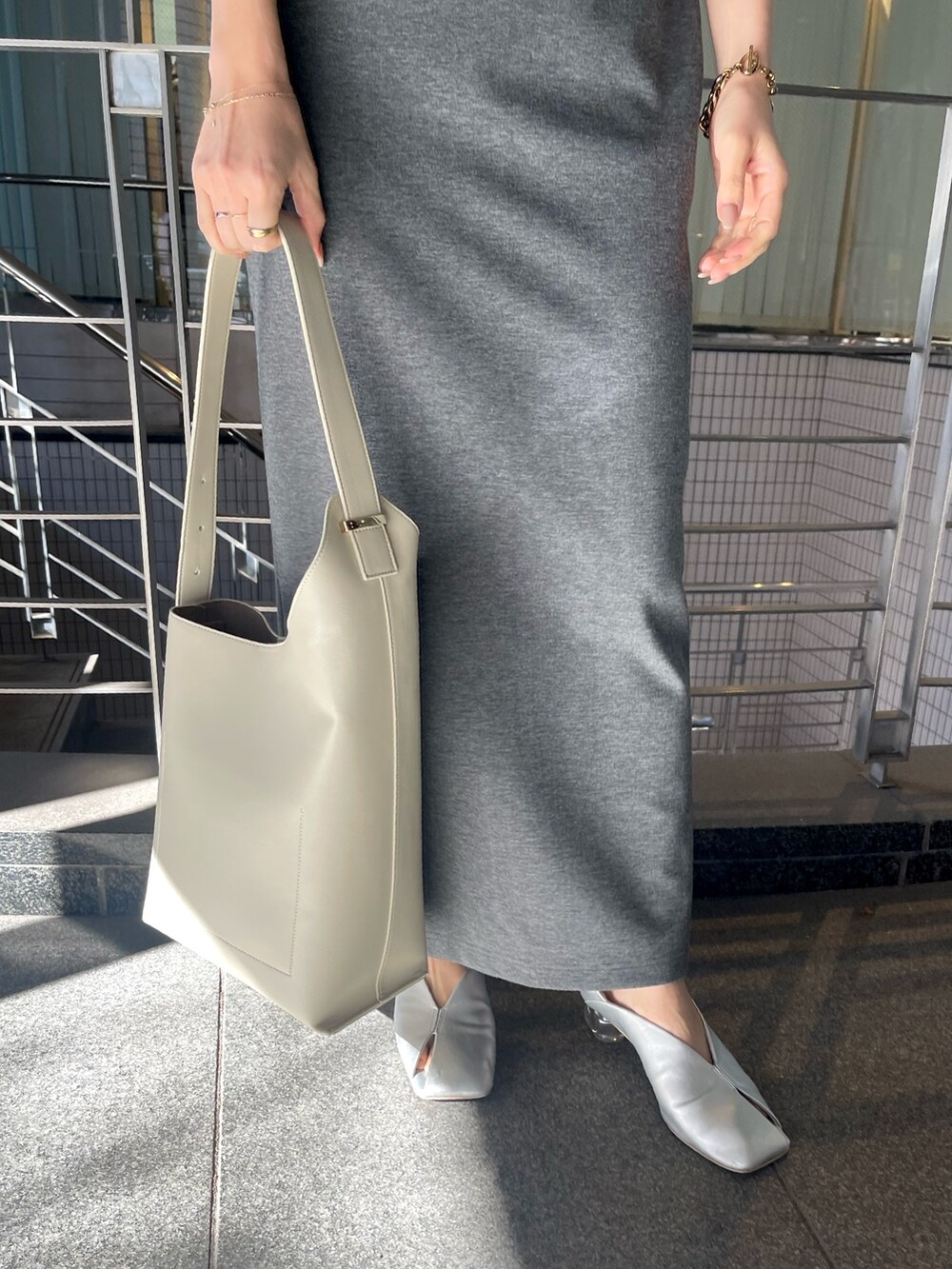 グレー系のワンピース、ホワイト系のショルダーバッグ、シルバー系のパンプスを着用したレディースの冬コーディネートの10枚目の写真