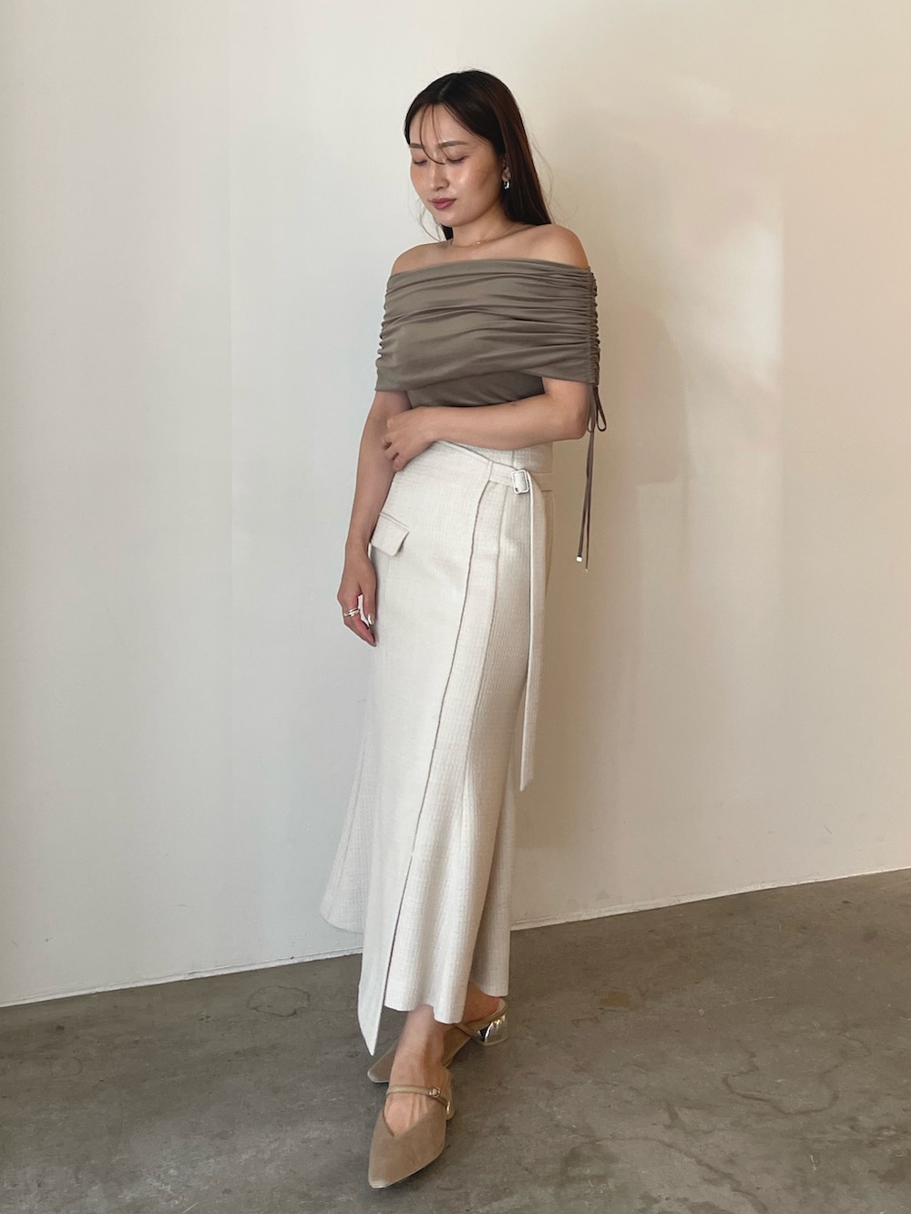 ベージュ系のパンプス、ブラウン系のTシャツ/カットソー、ホワイト系のスカートを着用したレディースの夏コーディネートの2枚目の写真