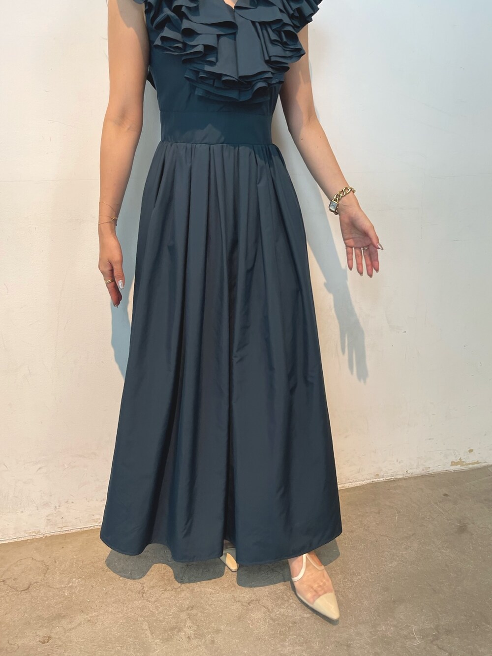 ベージュ系のパンプス、グリーン系のドレス、ゴールド系のピアス（両耳用）を着用したレディースの夏コーディネートの7枚目の写真