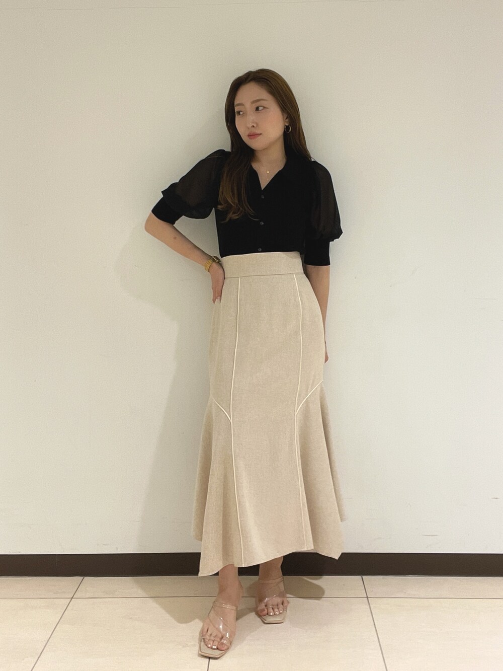 ブラック系のニット/セーター、ホワイト系のスカートを着用したレディースの夏コーディネートの2枚目の写真