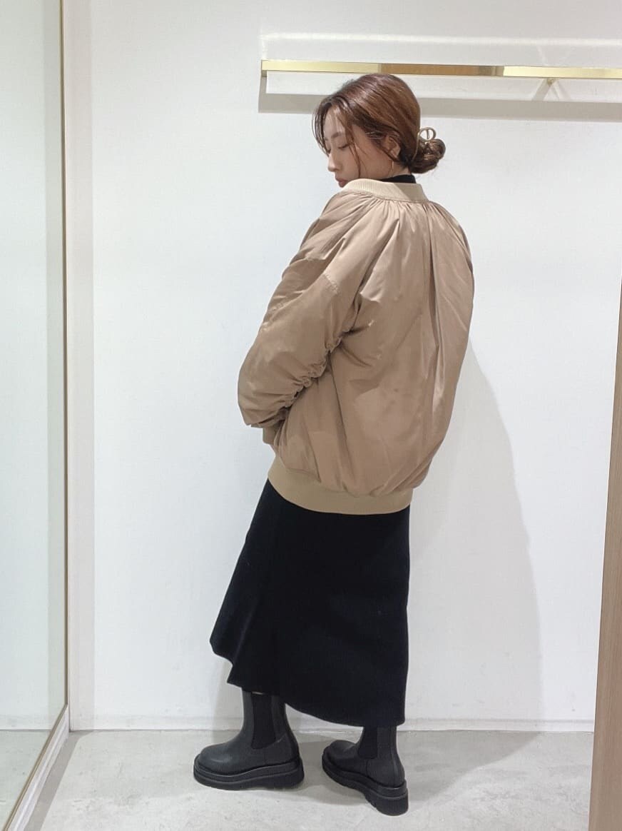 ブラック系のブーツ、ブラック系のニット/セーター、ブラック系のスカートを着用したレディースの秋コーディネートの5枚目の写真