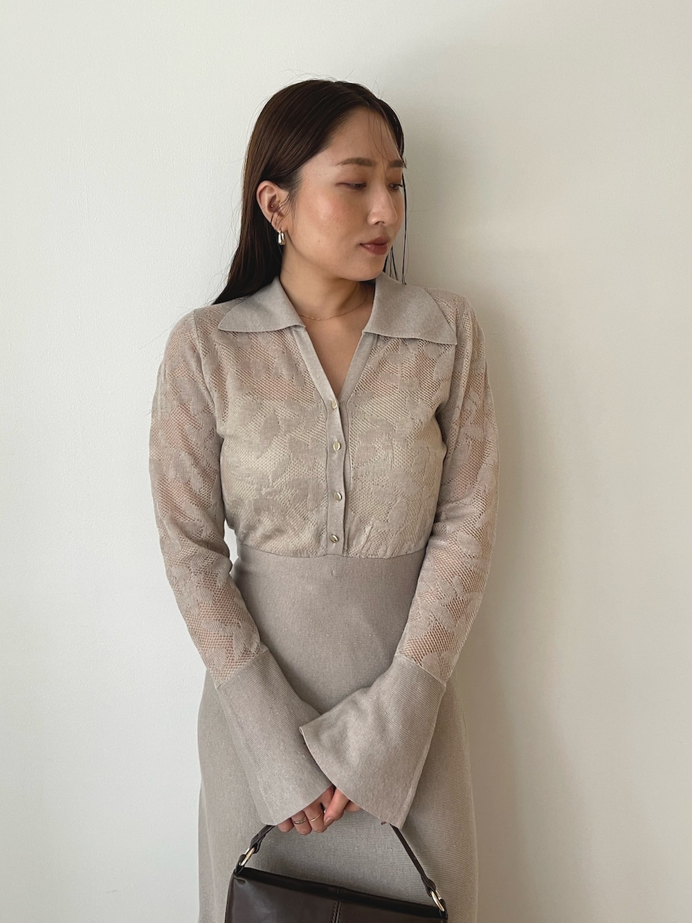 ブラウン系のハンドバッグ、ベージュ系のワンピース、ブラウン系のブーツを着用したレディースの秋コーディネートの8枚目の写真