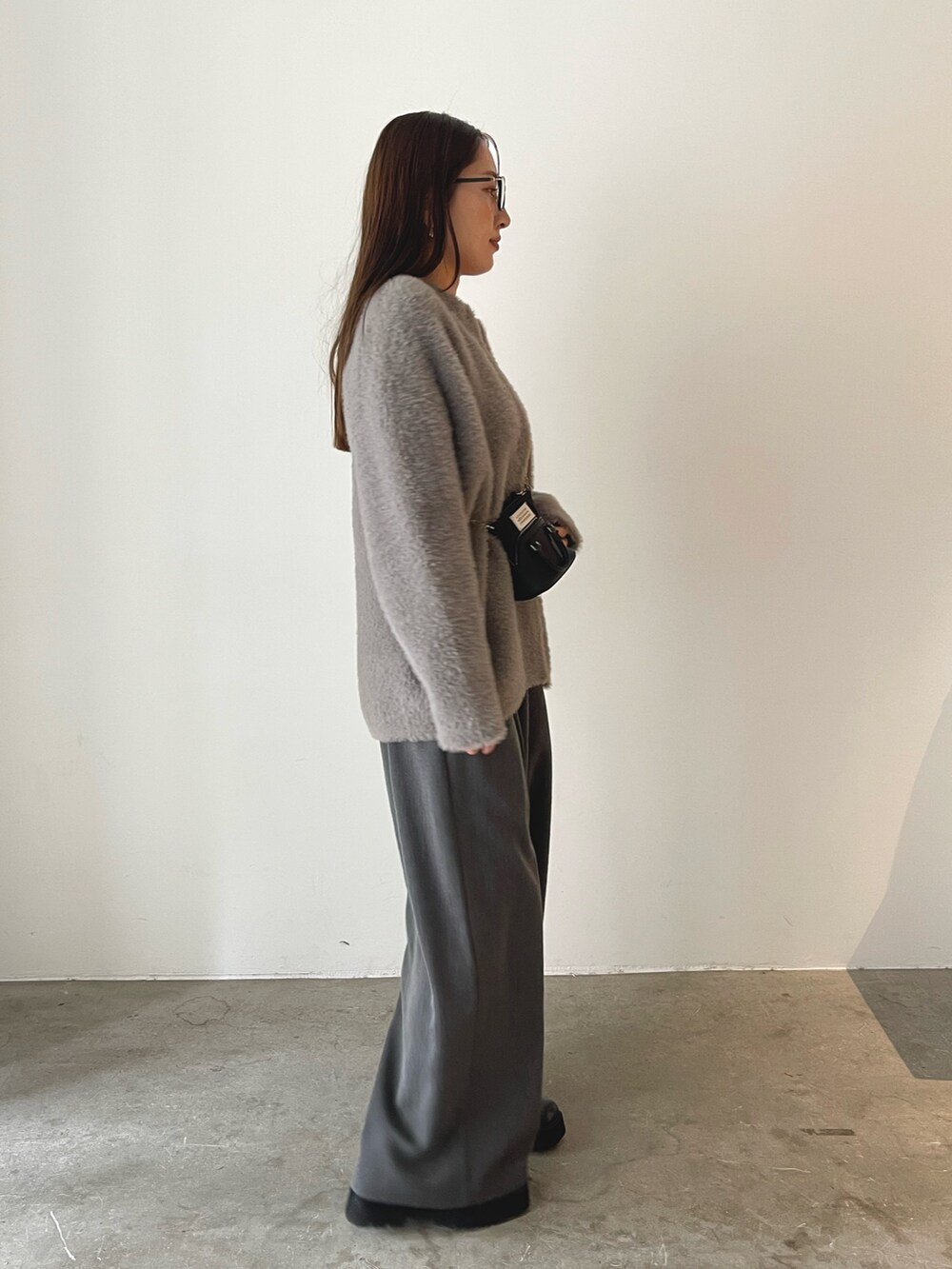 ブラック系のローファー、グレー系のその他パンツ、レッド系のニット/セーターを着用したレディースの秋コーディネートの7枚目の写真