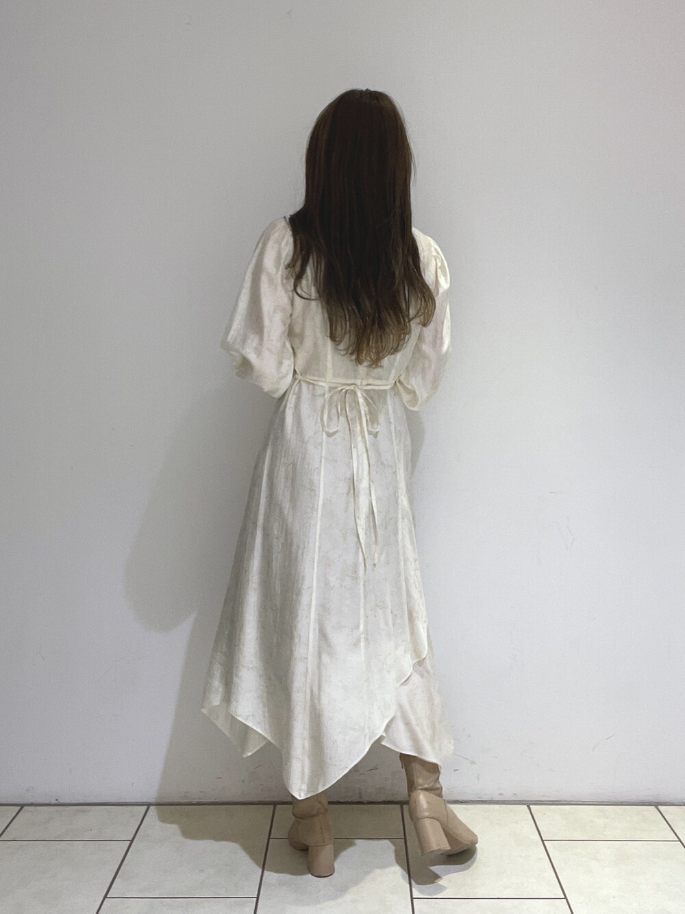 ベージュ系のブーツ、ホワイト系のワンピースを着用したレディースの冬コーディネートの8枚目の写真