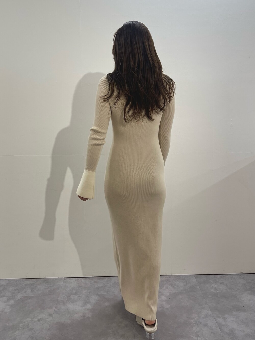 ホワイト系のワンピース、ホワイト系のパンプス、ゴールド系のイヤリングを着用したレディースの冬コーディネートの4枚目の写真