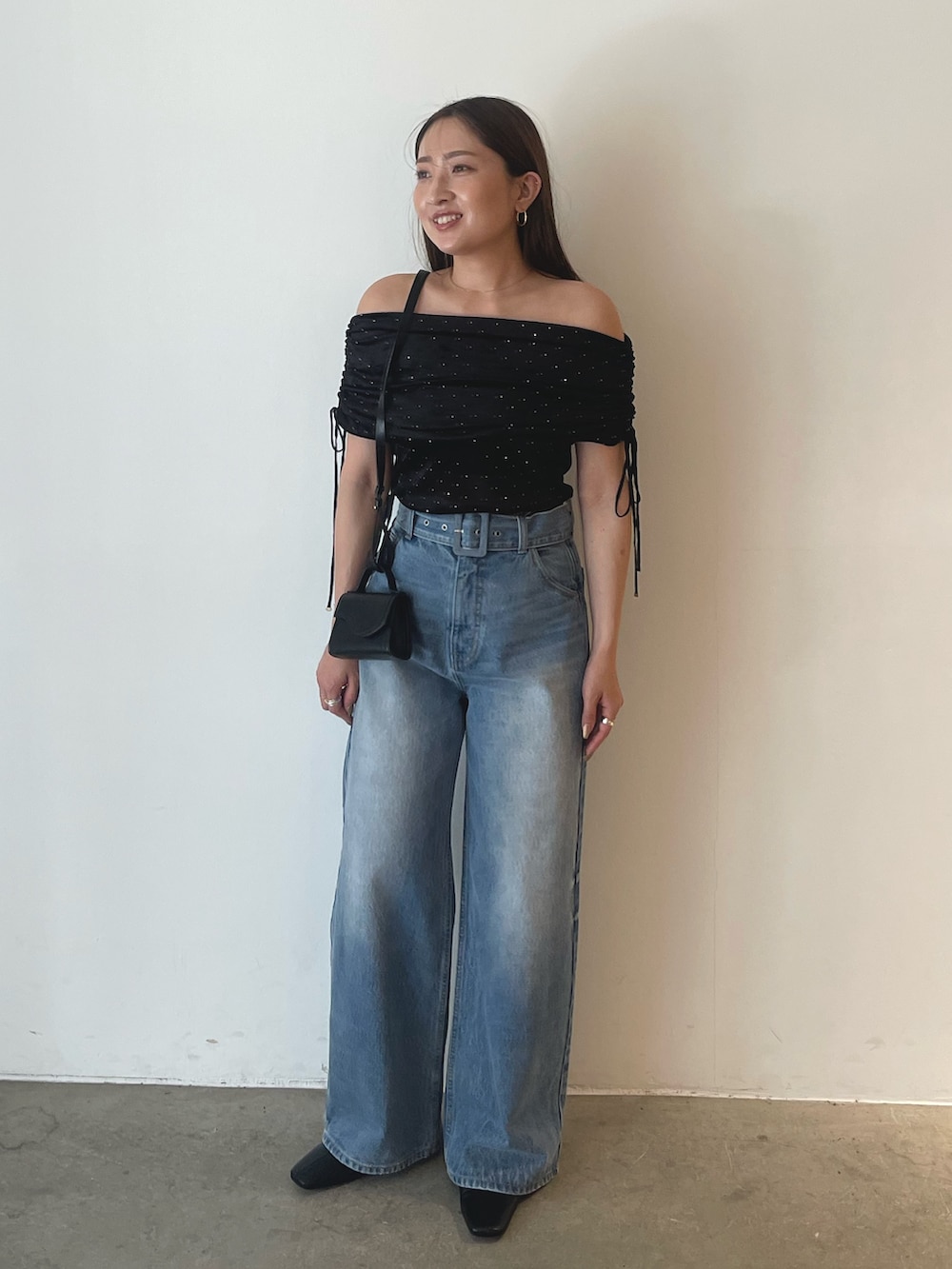 ブラック系のTシャツ/カットソー、ブルー系のデニムパンツを着用したレディースの夏コーディネートの2枚目の写真