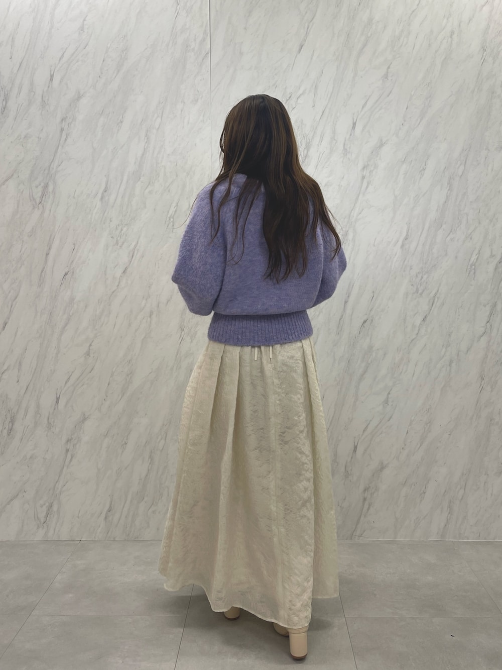 ホワイト系のスカート、ホワイト系のブーツ、パープル系のニット/セーターを着用したレディースの冬コーディネートの4枚目の写真