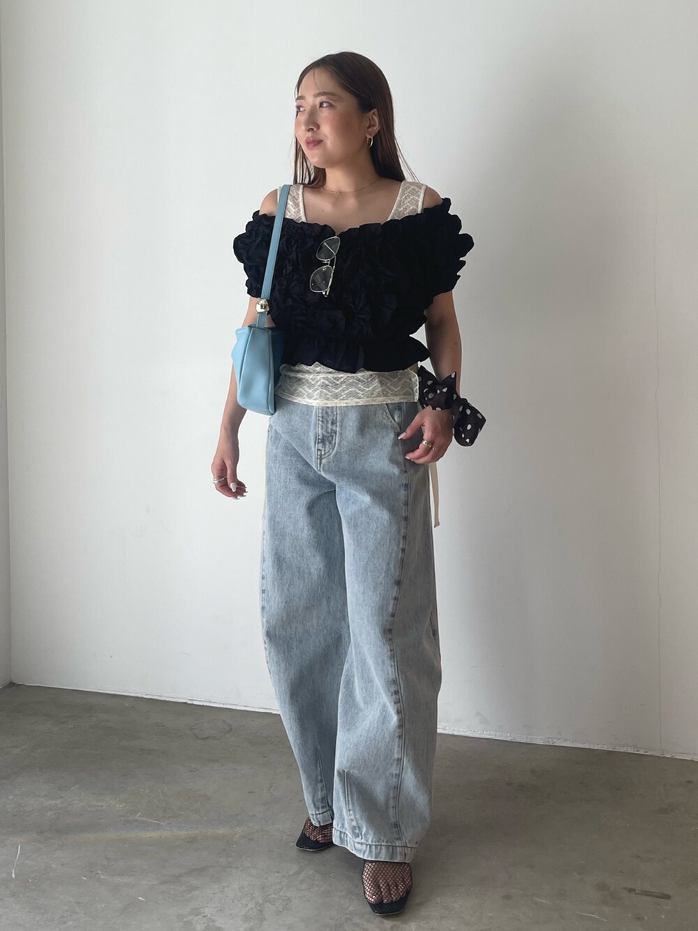 ブラック系のパンツドレス、ブルー系のデニムパンツ、ホワイト系のシャツ/ブラウスを着用したレディースの春コーディネートの4枚目の写真
