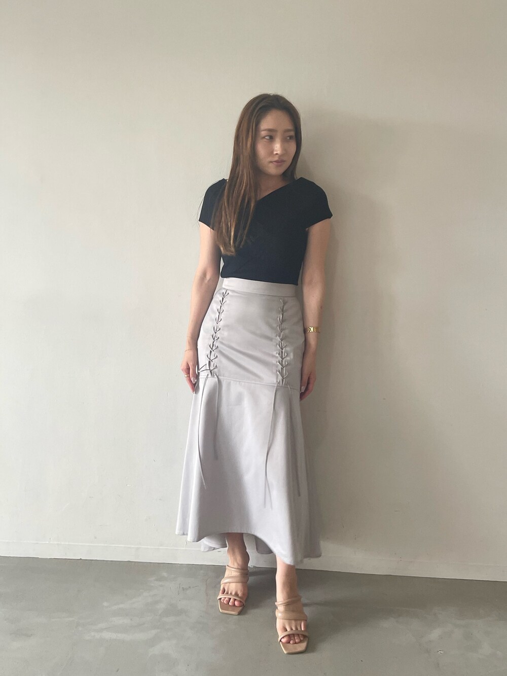 ブラック系のニット/セーター、グレー系のスカート、ベージュ系のサンダルを着用したレディースの夏コーディネートの5枚目の写真