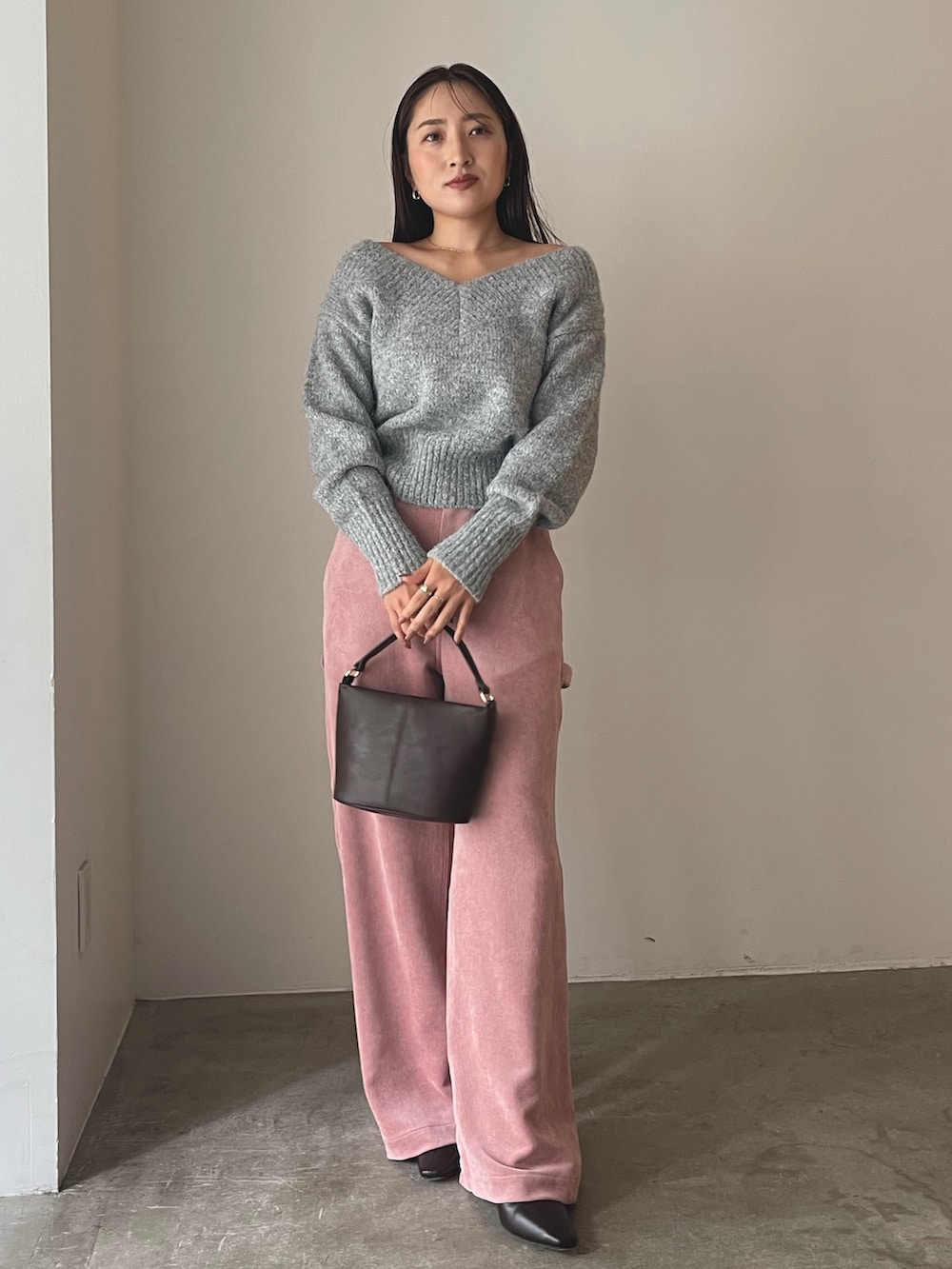 ブラウン系のハンドバッグ、ブラウン系のブーツ、ピンク系のその他パンツを着用したレディースの秋コーディネートの2枚目の写真