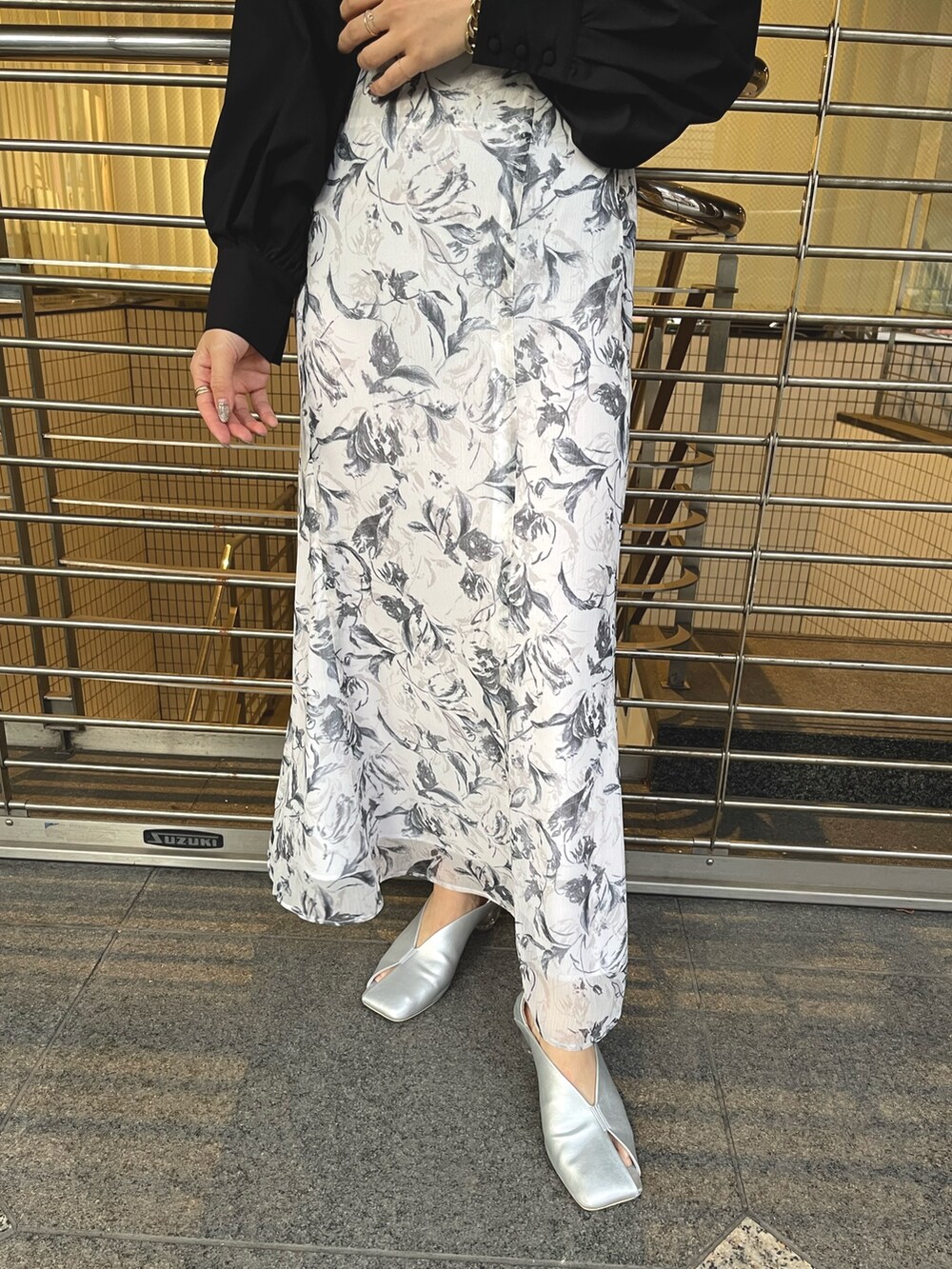 グレー系のスカート、シルバー系のパンプス、ブラック系のニット/セーターを着用したレディースの冬コーディネートの8枚目の写真