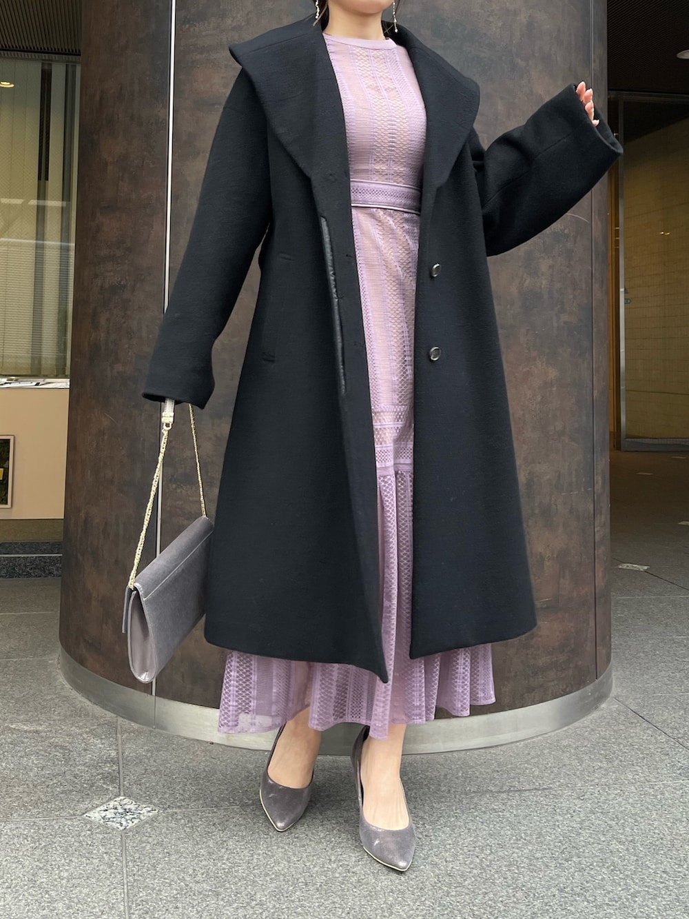 シルバー系のパンプス、シルバー系のハンドバッグ、ブラック系のその他アウターを着用したレディースの冬コーディネートの2枚目の写真