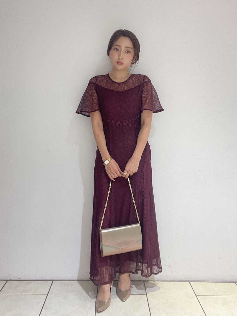 ゴールド系のクラッチバッグ、レッド系のドレス、ゴールド系のパンプスを着用したレディースの夏コーディネートの3枚目の写真