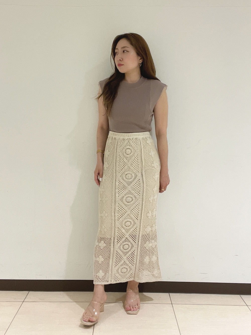 ホワイト系のスカート、ベージュ系のニット/セーターを着用したレディースの夏コーディネートの4枚目の写真
