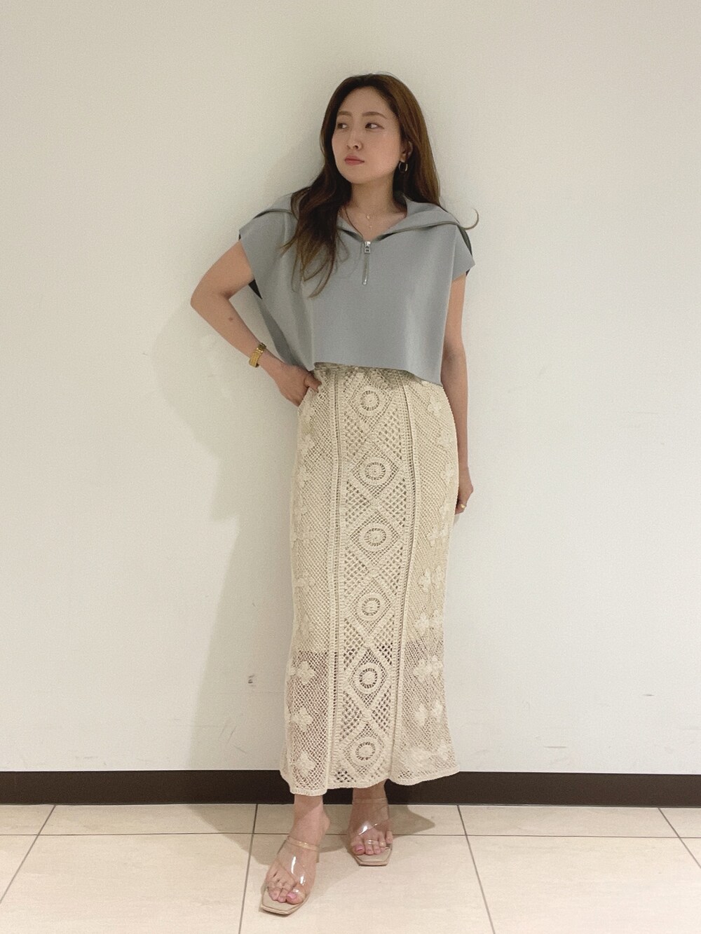 ブルー系のニット/セーター、ホワイト系のスカートを着用したレディースの春コーディネートの4枚目の写真