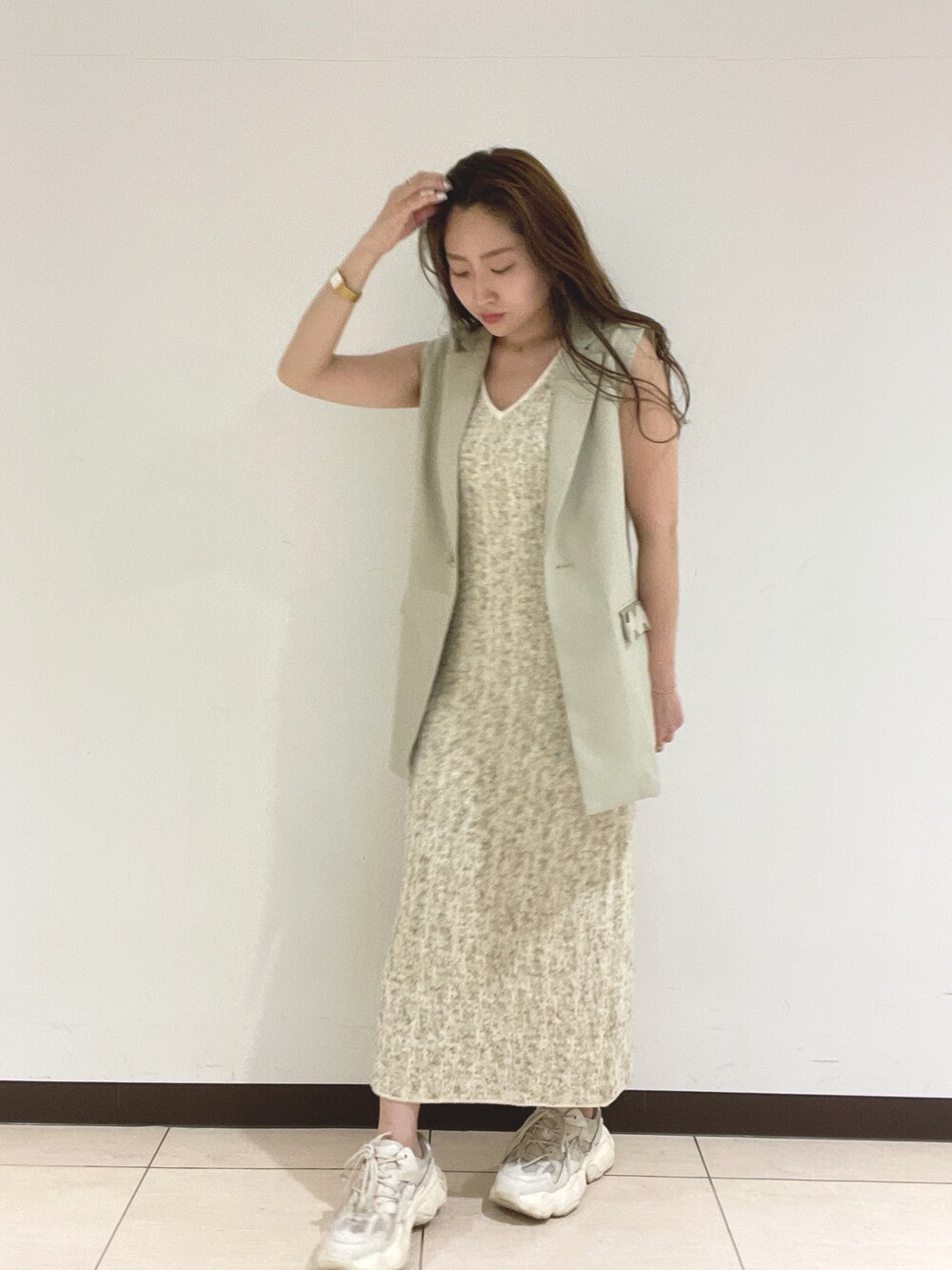 ホワイト系のワンピース、ベージュ系のベストを着用したレディースの春コーディネートの7枚目の写真