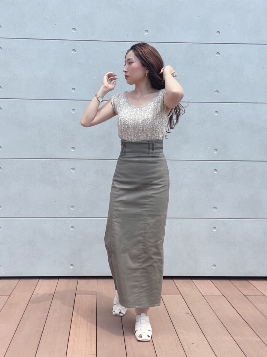 グレー系のスカート、ホワイト系のサンダル、ホワイト系のニット/セーターを着用したレディースの夏コーディネートの7枚目の写真