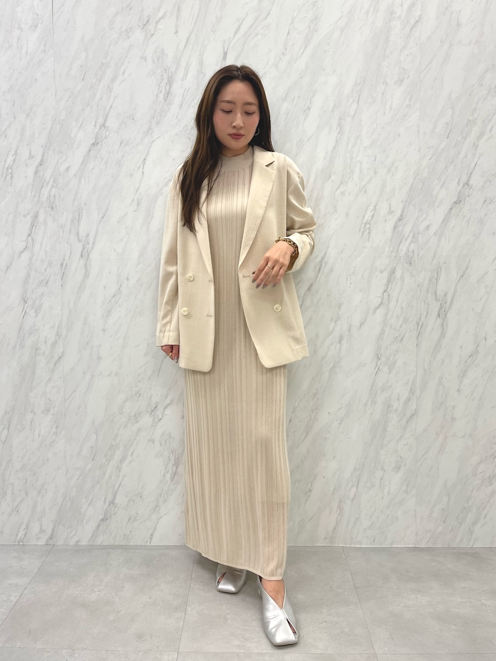 シルバー系のパンプス、ベージュ系のテーラードジャケット、ホワイト系のワンピースを着用したレディースの春コーディネートの4枚目の写真