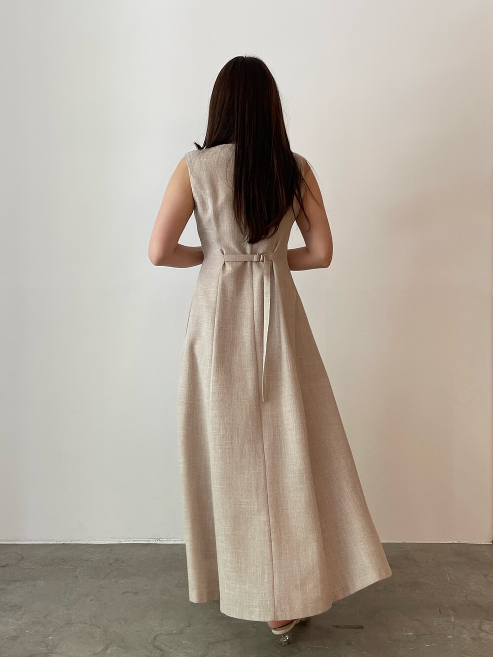 ベージュ系のワンピース、ホワイト系のサンダル、ホワイト系のテーラードジャケットを着用したレディースの夏コーディネートの7枚目の写真