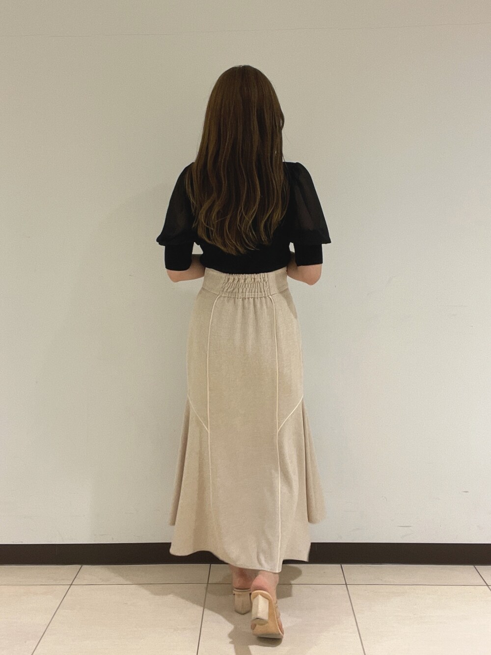 ブラック系のニット/セーター、ホワイト系のスカートを着用したレディースの夏コーディネートの8枚目の写真