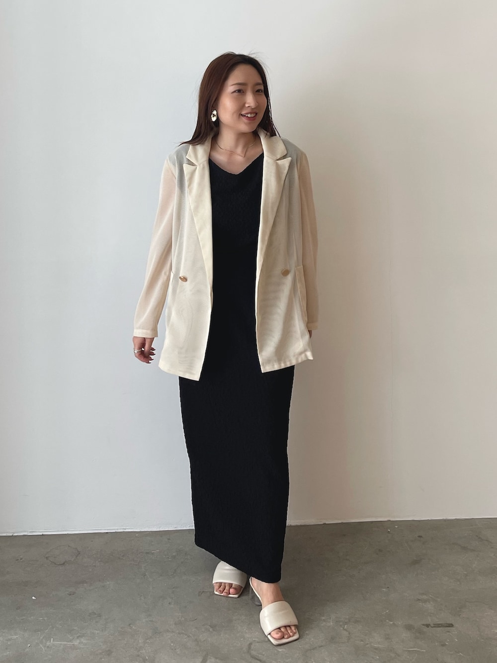 ホワイト系のサンダル、ブラック系のスカート、ブラック系のTシャツ/カットソーを着用したレディースの春コーディネートの3枚目の写真