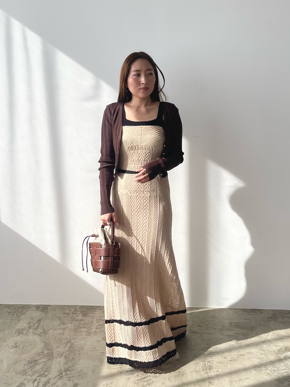 ベージュ系のワンピース、ブラウン系のカーディガン/ボレロ、シルバー系のパンプスを着用したレディースの春コーディネートの3枚目の写真