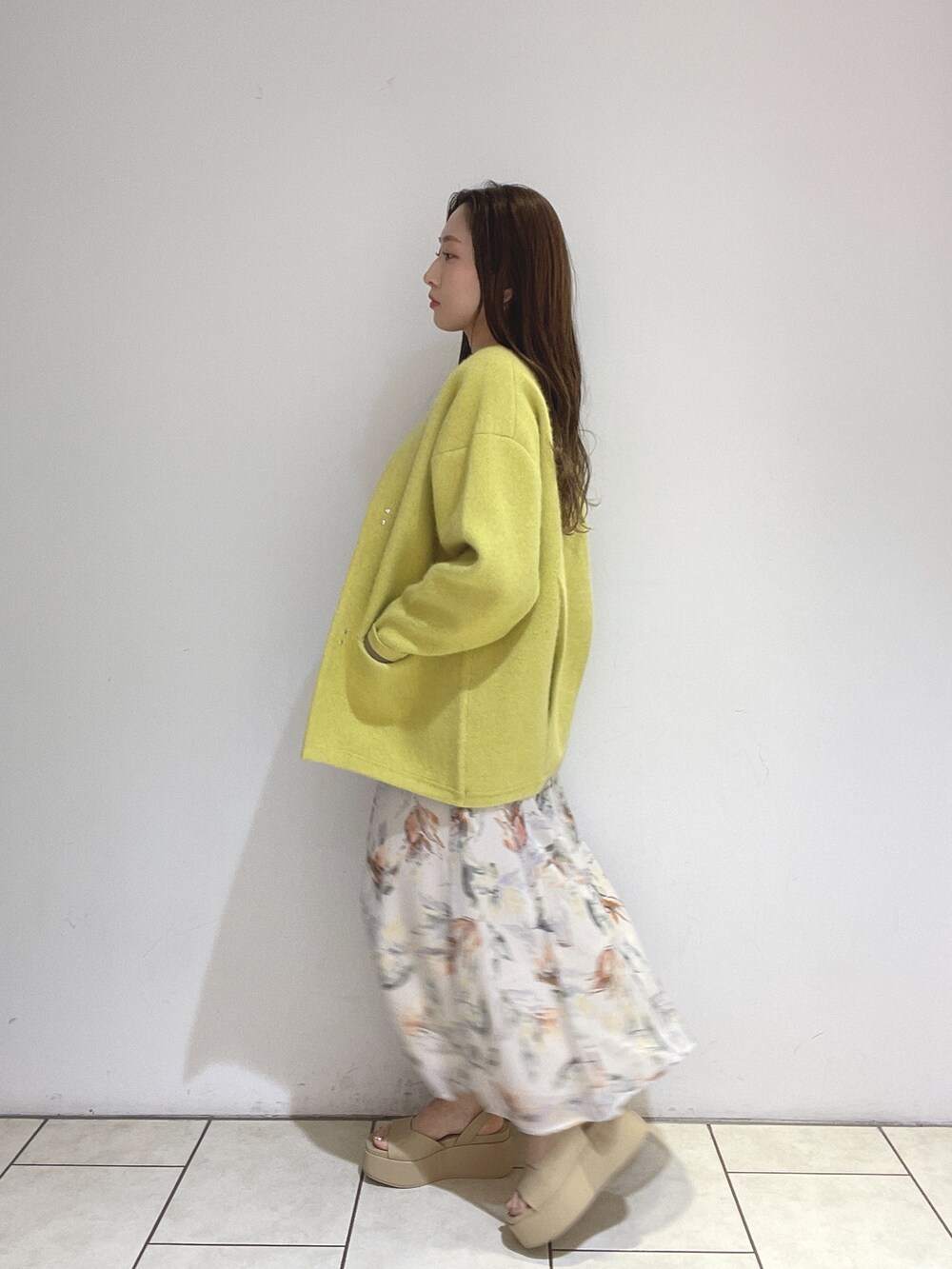 ホワイト系のワンピース、イエロー系のカーディガン/ボレロ、ベージュ系のサンダルを着用したレディースの冬コーディネートの6枚目の写真