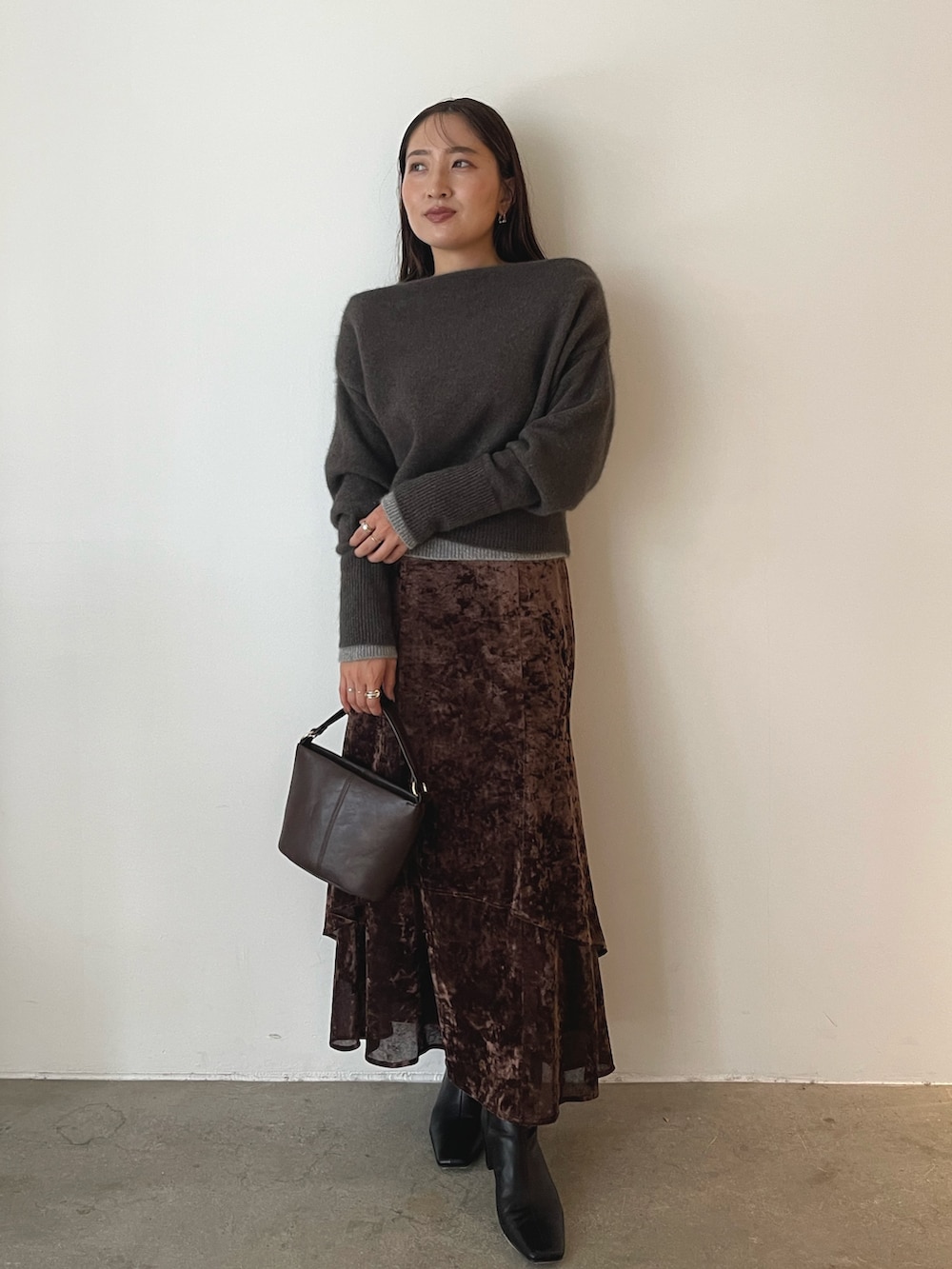 ブラウン系のハンドバッグ、ブラウン系のニット/セーター、ブラウン系のスカートを着用したレディースの秋コーディネートの9枚目の写真