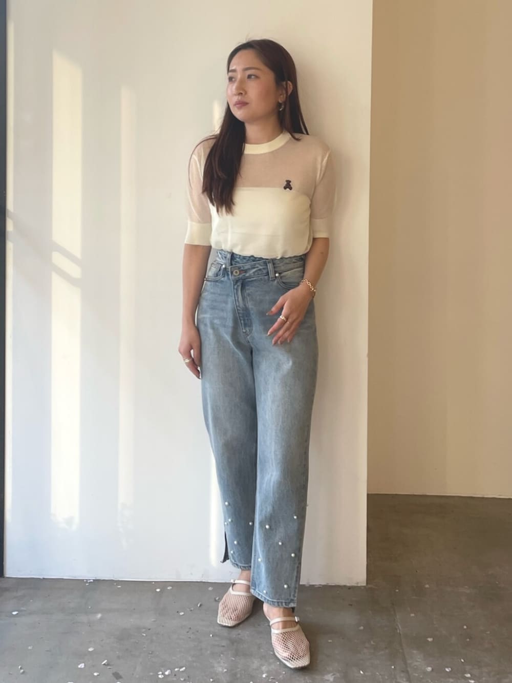 ホワイト系のサンダル、ブルー系のデニムパンツ、ホワイト系のTシャツ/カットソーを着用したレディースの春コーディネートの4枚目の写真