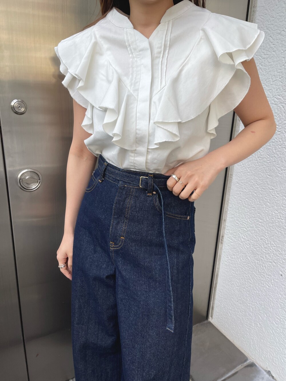 ホワイト系のサンダル、ホワイト系のシャツ/ブラウス、ブルー系のデニムパンツを着用したレディースの春コーディネートの9枚目の写真