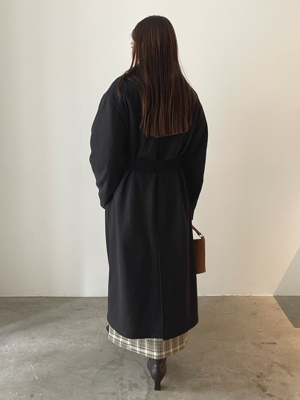 ブラウン系のスカート、イエロー系のハンドバッグ、グレー系のチェスターコートを着用したレディースの秋コーディネートの5枚目の写真