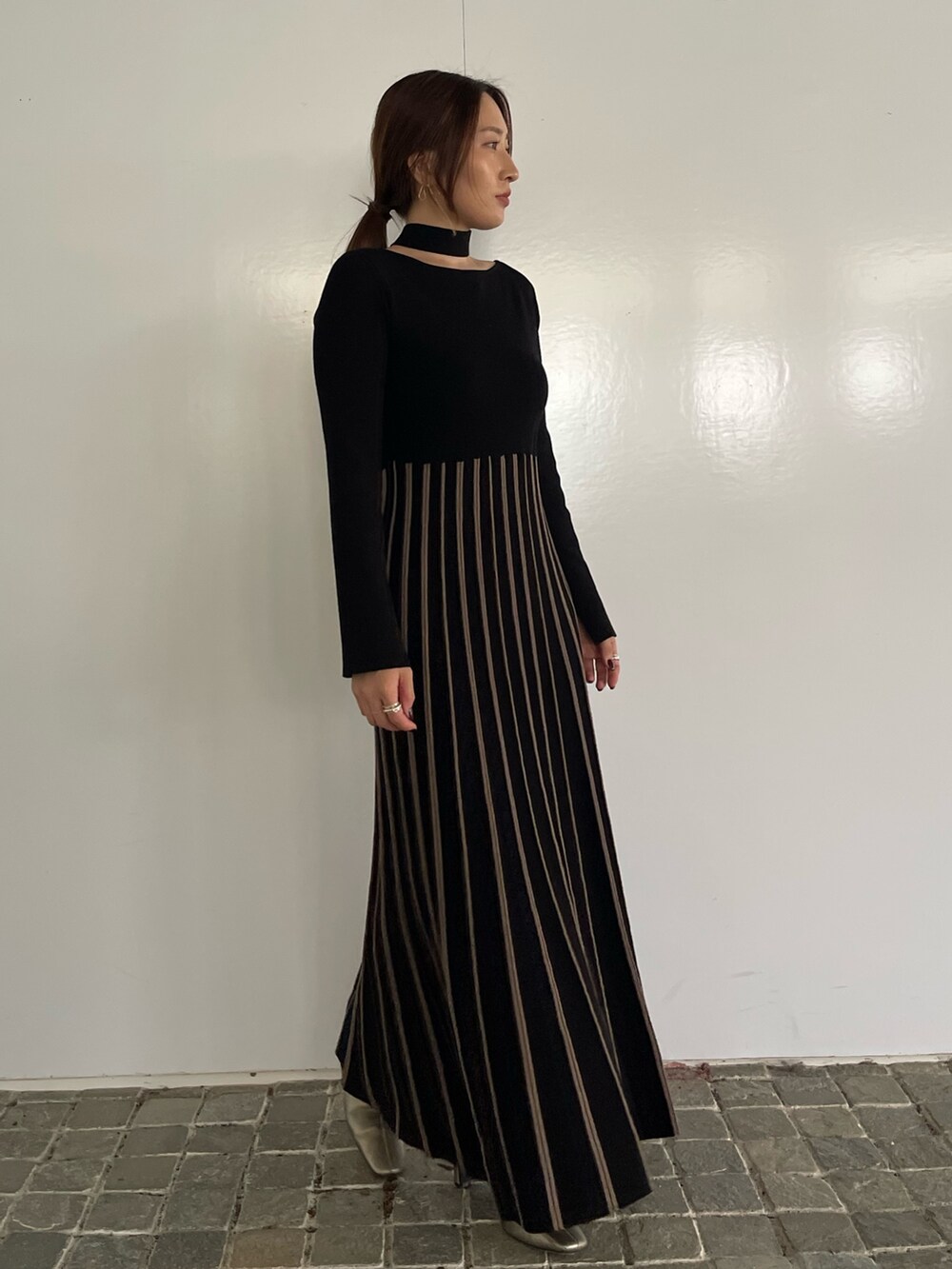 ブラック系のワンピース、シルバー系のブーツを着用したレディースの冬コーディネートの2枚目の写真