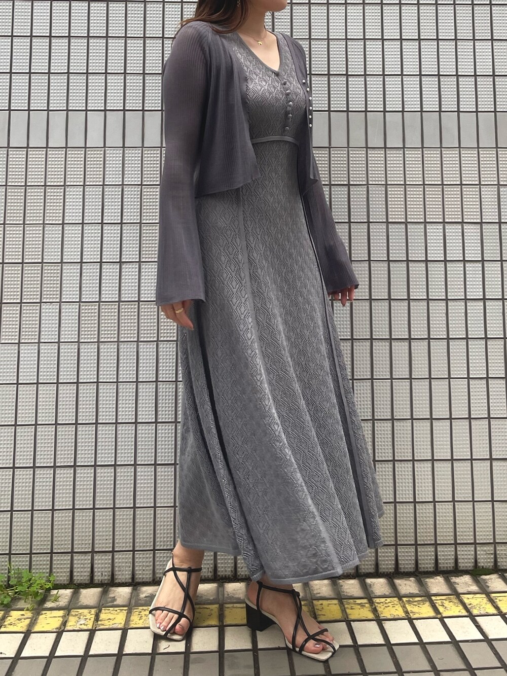 グレー系のワンピース、ブラック系のサンダル、グレー系のカーディガン/ボレロを着用したレディースの春コーディネートの6枚目の写真
