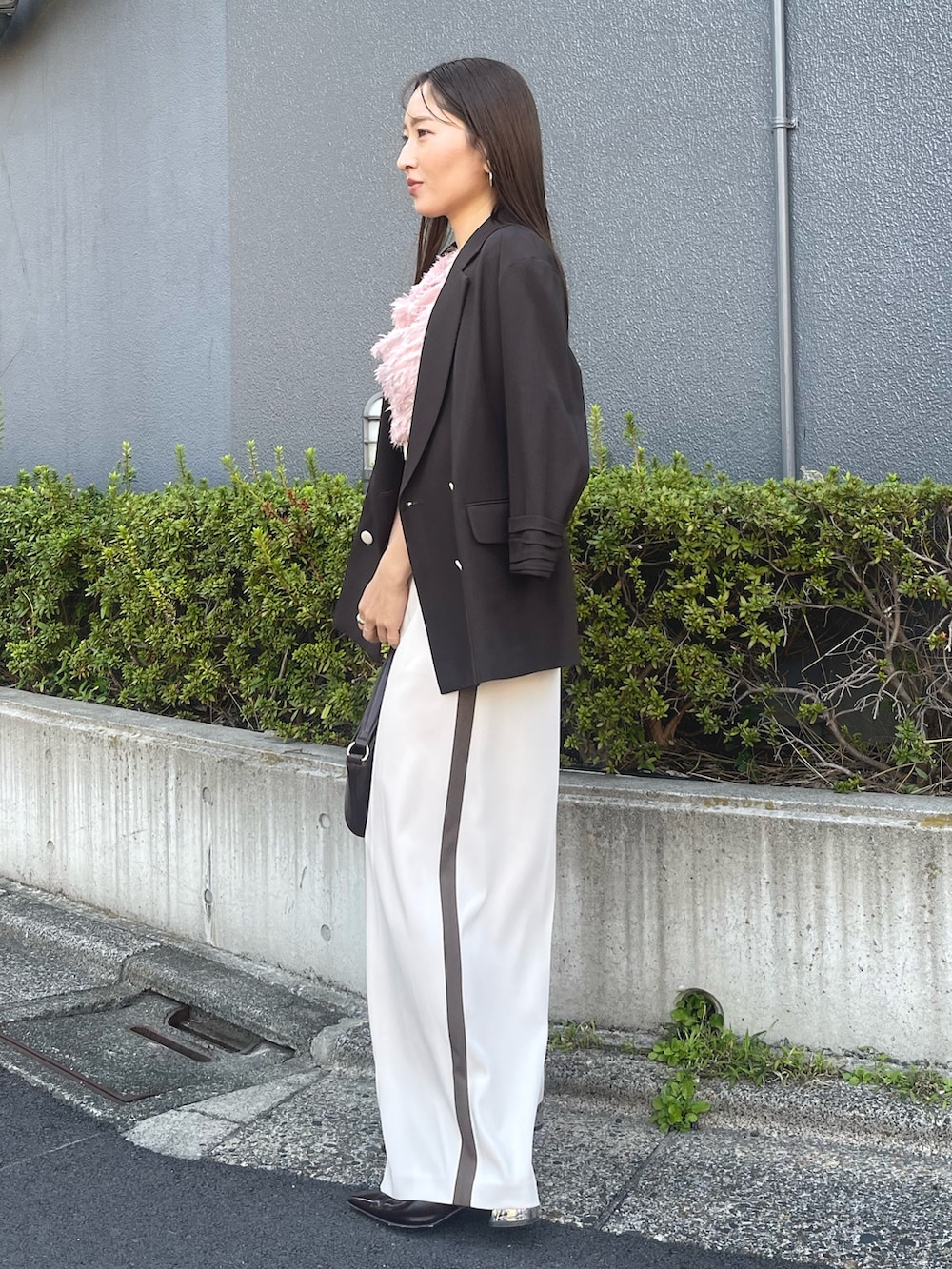 ブラウン系のハンドバッグ、ピンク系のシャツ/ブラウス、ブラック系のパンプスを着用したレディースの冬コーディネートの6枚目の写真