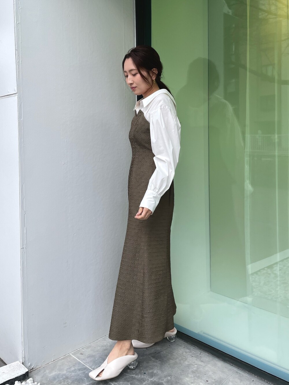 ホワイト系のパンプス、ブラウン系のワンピース、ゴールド系のネックレスを着用したレディースの春コーディネートの7枚目の写真