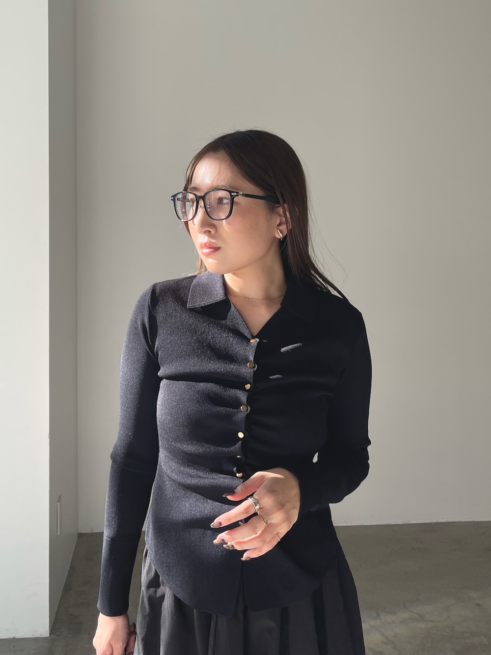 シルバー系のパンプス、ブラック系のワンピース、ゴールド系のピアス（両耳用）を着用したレディースの冬コーディネートの8枚目の写真