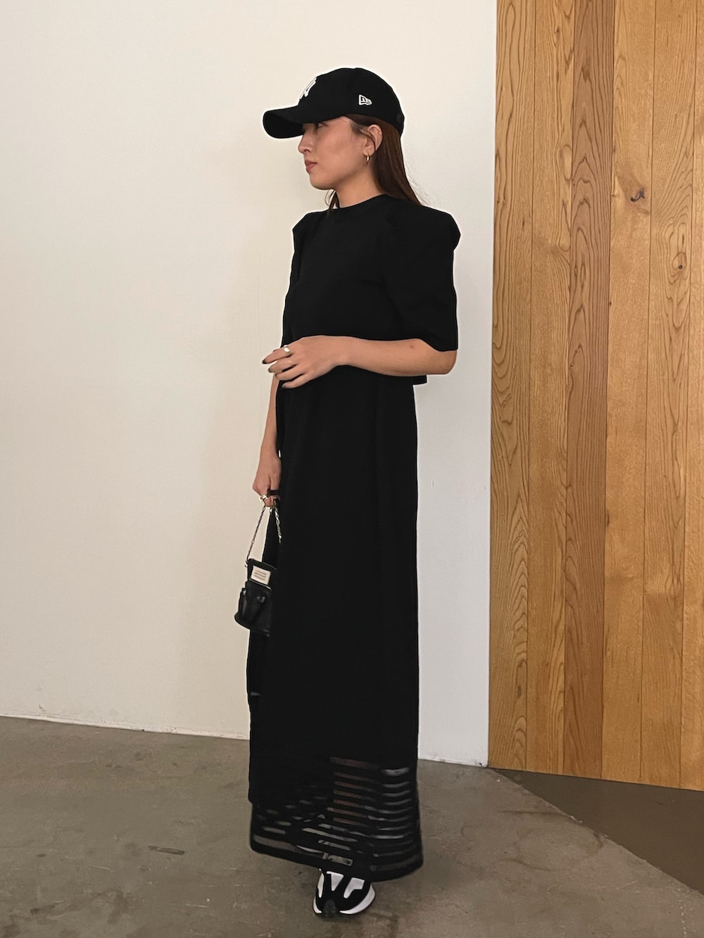 ブラック系のワンピース、ブラック系のキャップを着用したレディースの冬コーディネートの2枚目の写真