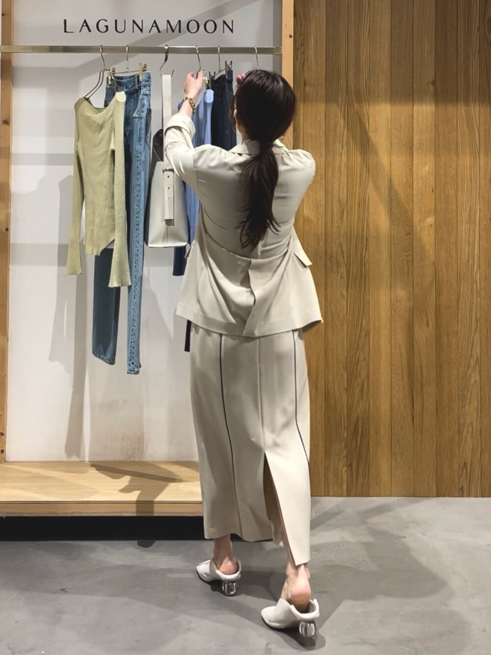 ベージュ系のスカート、ホワイト系のパンプス、ブラック系のニット/セーターを着用したレディースの冬コーディネートの3枚目の写真