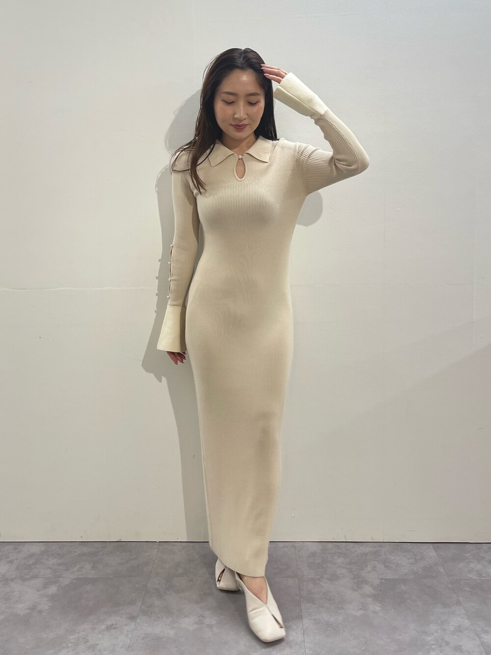 ホワイト系のワンピース、ホワイト系のパンプス、ゴールド系のイヤリングを着用したレディースの冬コーディネートの3枚目の写真