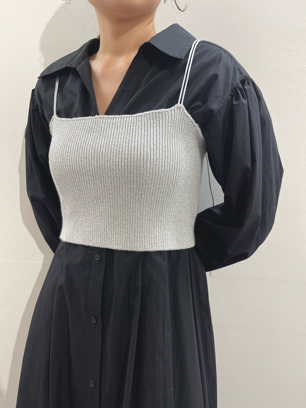 ホワイト系のパンプス、ブラック系のシャツワンピース、シルバー系のイヤリングを着用したレディースの冬コーディネートの7枚目の写真