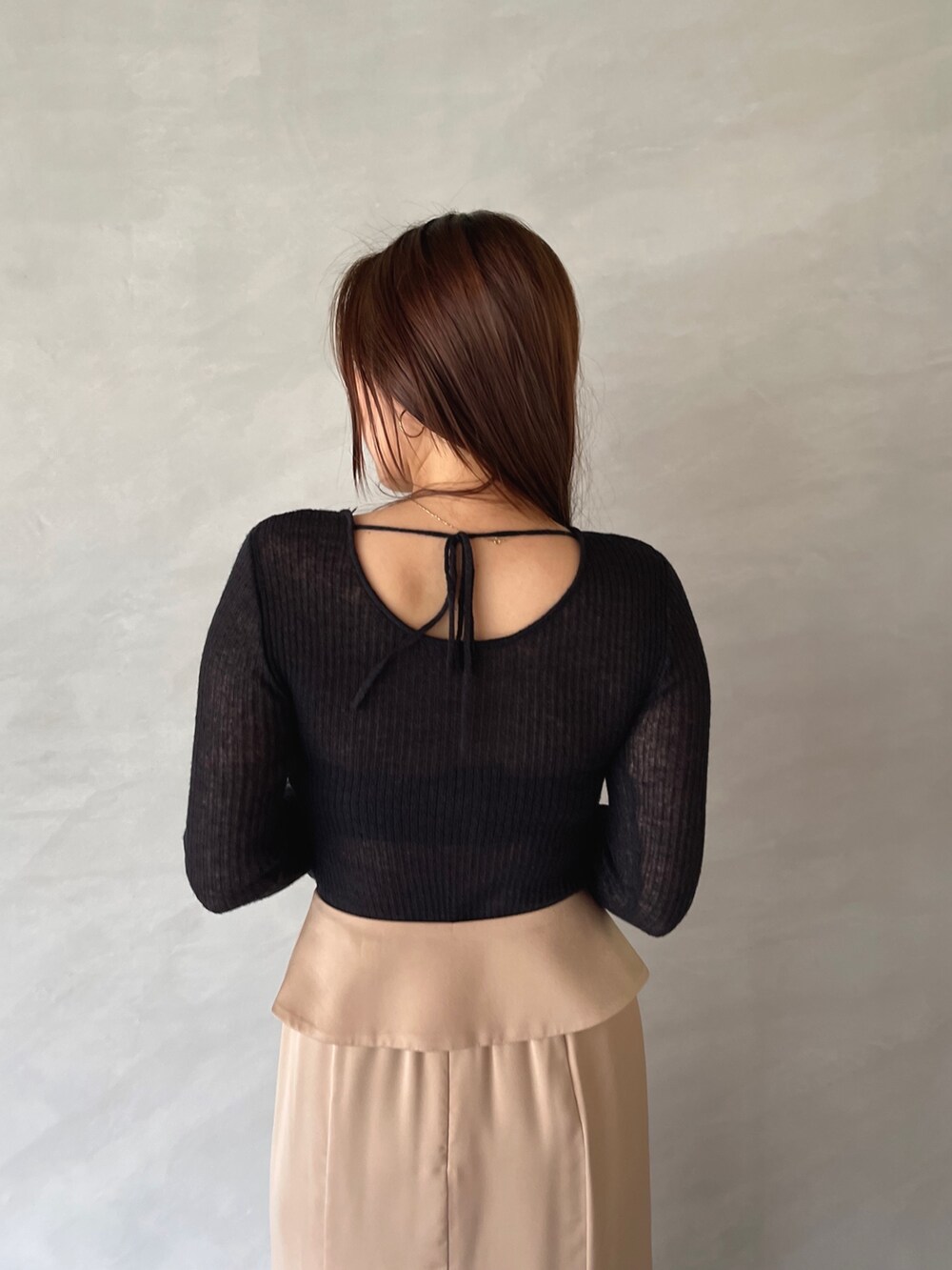 ベージュ系のスカート、ブラック系のニット/セーターを着用したレディースの夏コーディネートの9枚目の写真