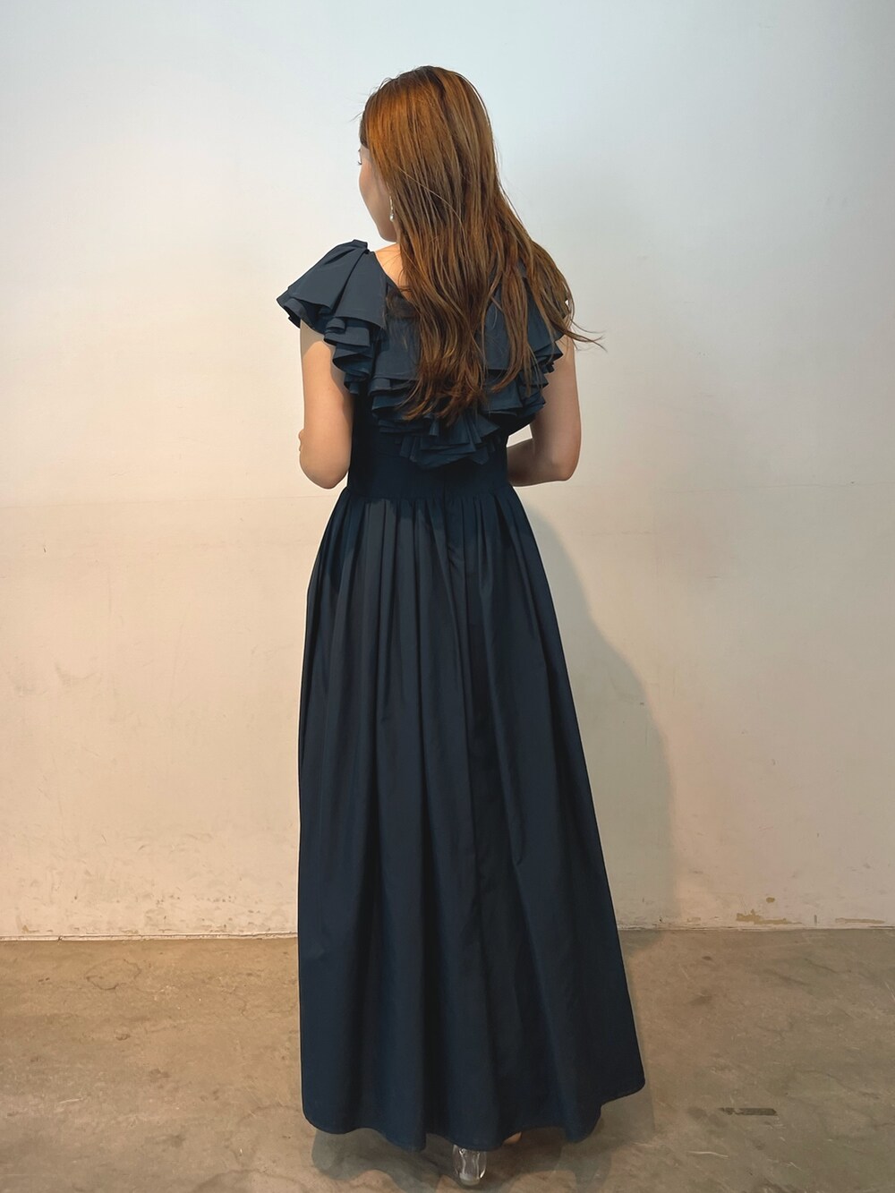 ベージュ系のパンプス、グリーン系のドレス、ゴールド系のピアス（両耳用）を着用したレディースの夏コーディネートの4枚目の写真