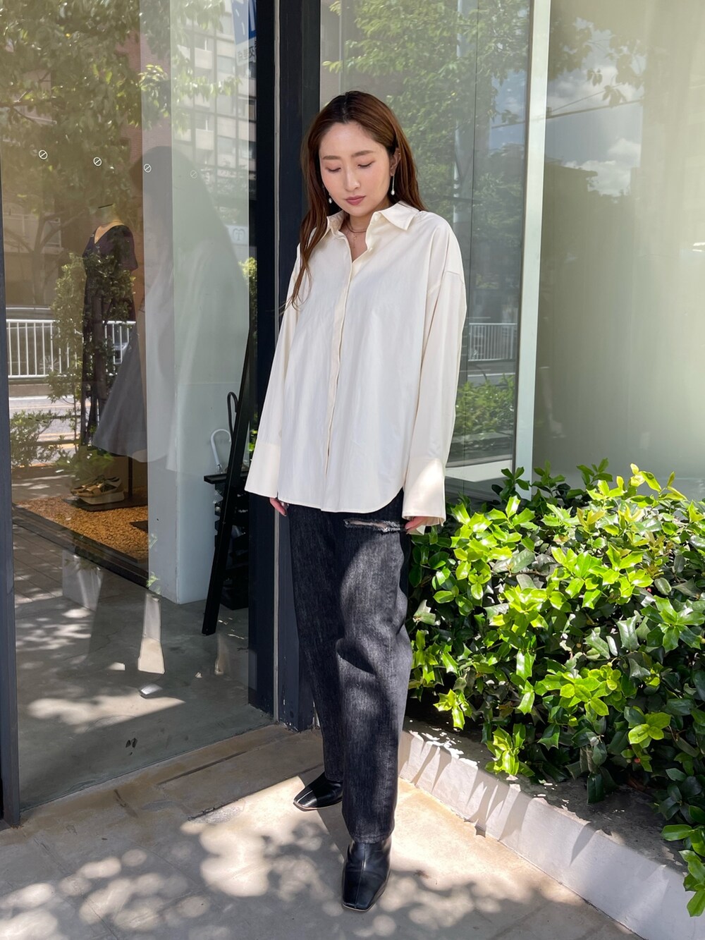 ホワイト系のシャツ/ブラウス、ブラック系のブーツ、ブラック系のデニムパンツを着用したレディースの秋コーディネートの2枚目の写真