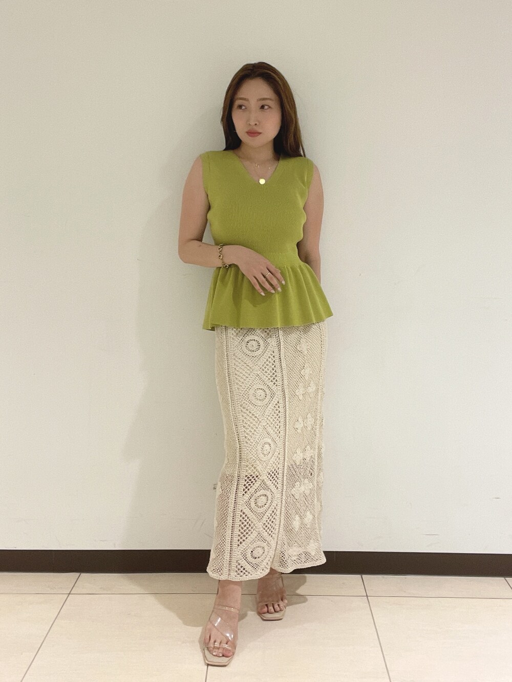 ホワイト系のスカート、グリーン系のニット/セーターを着用したレディースの夏コーディネートの2枚目の写真